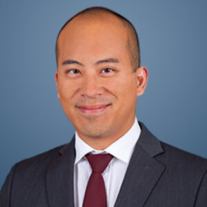 Michael Chung smiling in a headshot against a blue background