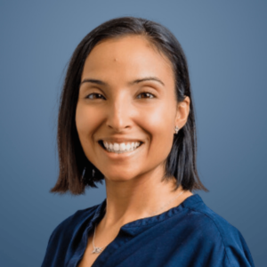 Dr. Jaspreet Chahal smiling in a headshot against a blue background