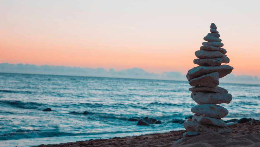 Rocks stacked at the beach at sunset