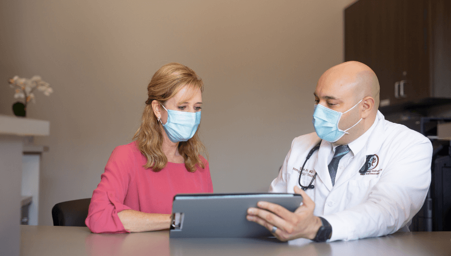 Physician and Patient Looking at Clipboard