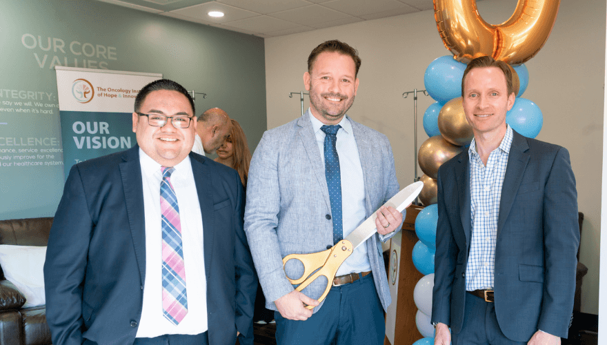 Three men pose for photo for celebration of clinic opening