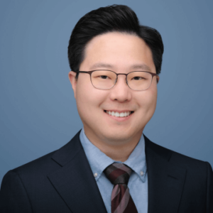 Headshot of Asian physician smiling for his headshot - wearing a suit and tie